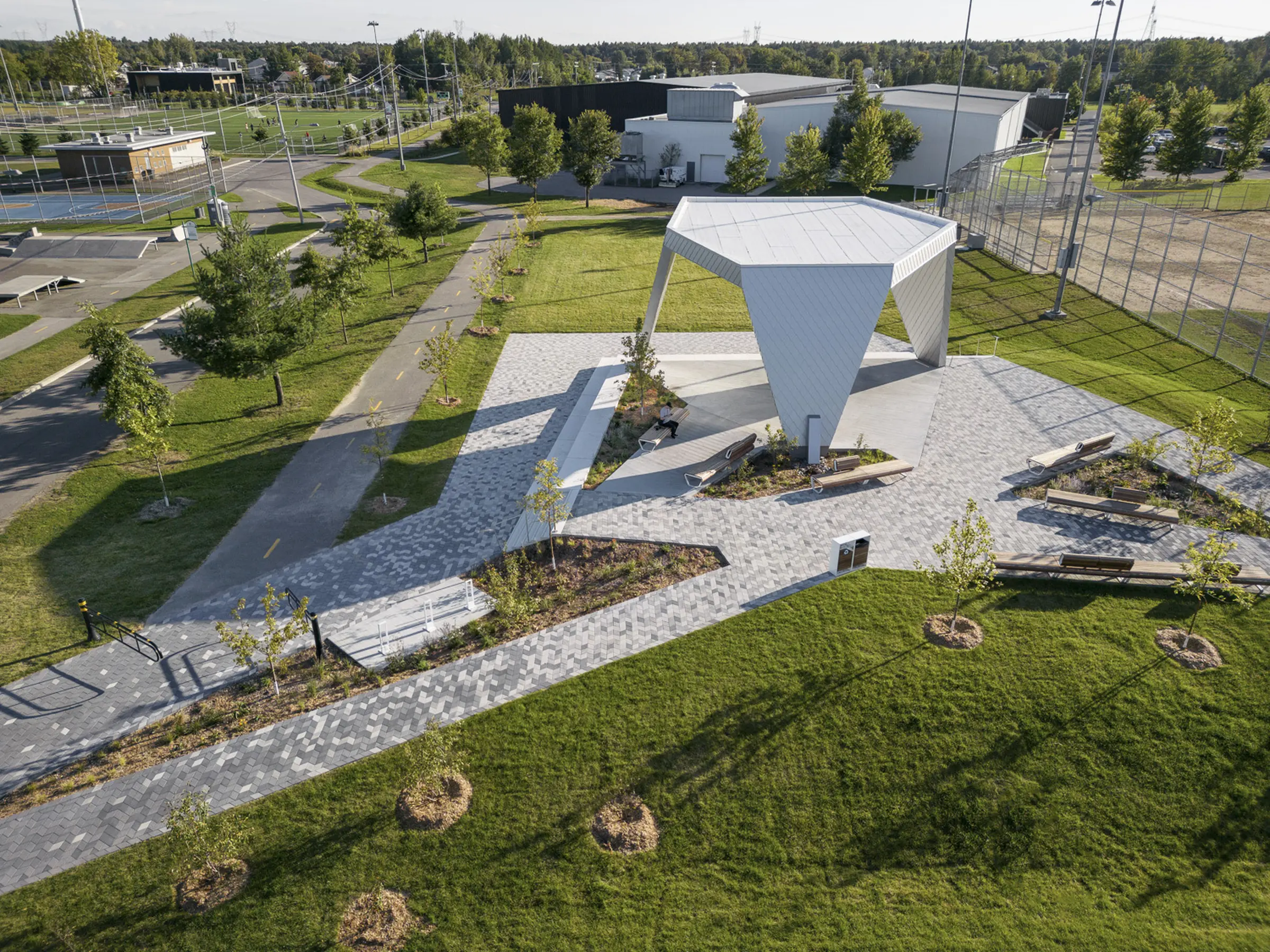 Vue d'ensemble du parc Philippe-Villeneuve avec la scène, la piste cyclable, les terrains de jeu